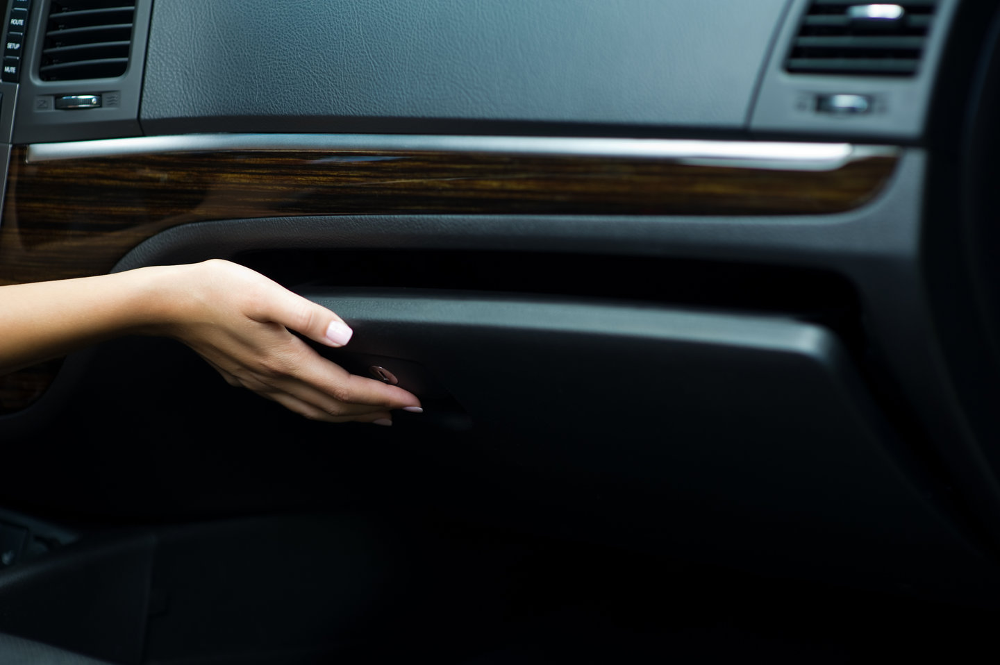 woman's hand closes the glove box in the car